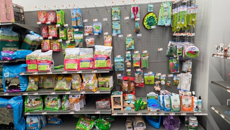 Small-animal food, hay and treats on shelves and pegboard